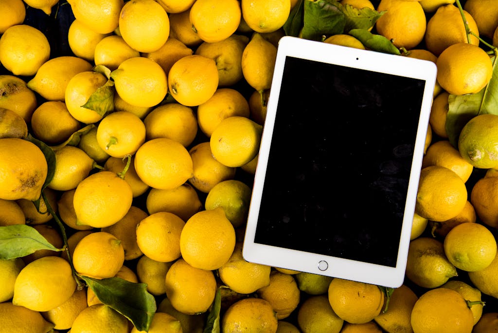 A bright, fresh collection of lemons with a blank tablet screen for copyspace.